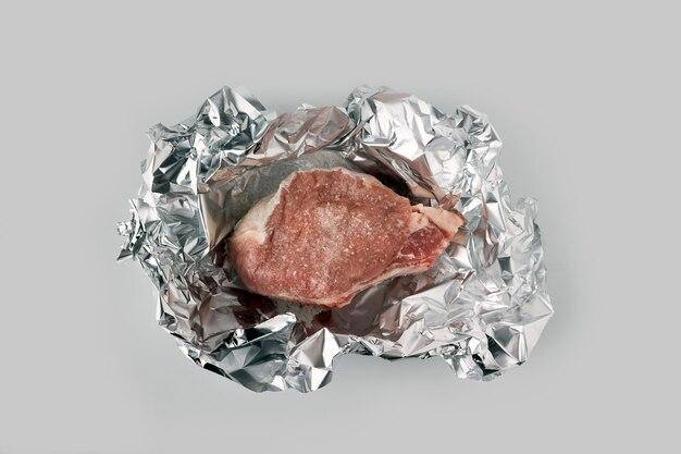 Can you wrap raw meat in aluminum foil? 