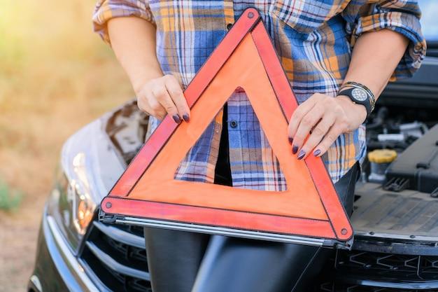 At what distance should the warning triangle be placed if a vehicle breaks down outside city limits? 